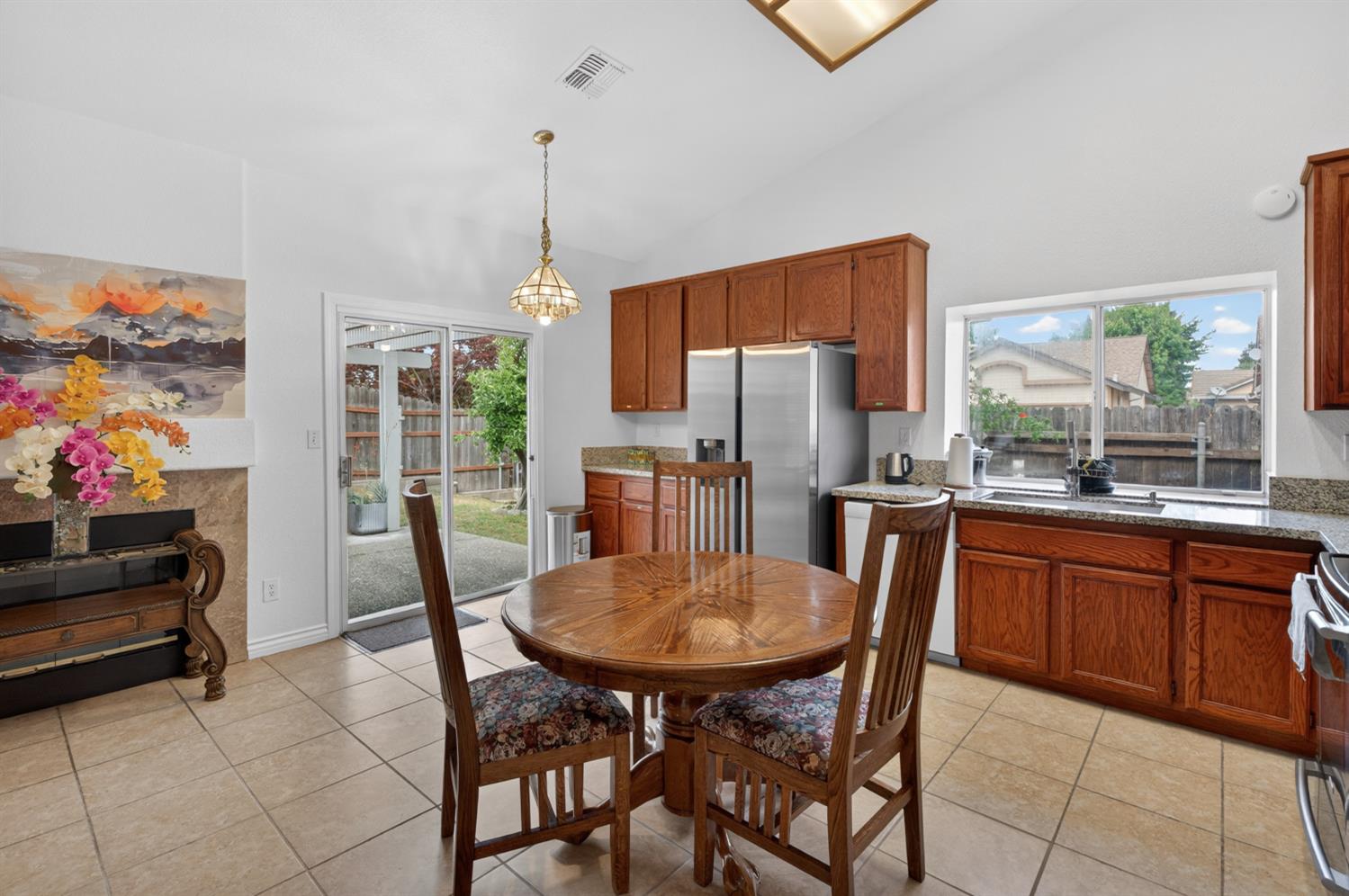 8148 Silverleaf Way Sacramento, CA 95829 - Photo 19 of 43 a kitchen with stainless steel appliances granite countertop a refrigerator a stove top oven a sink dishwasher and a dining table with wooden floor