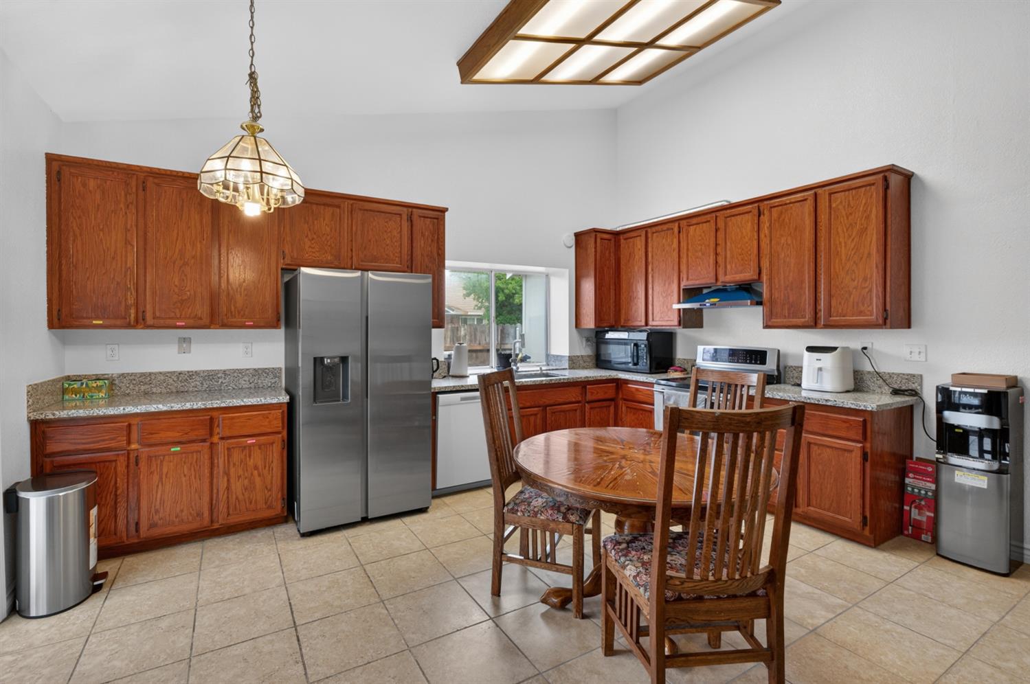 8148 Silverleaf Way Sacramento, CA 95829 - Photo 20 of 43 a kitchen with stainless steel appliances granite countertop a stove a refrigerator a sink a dining table and chairs