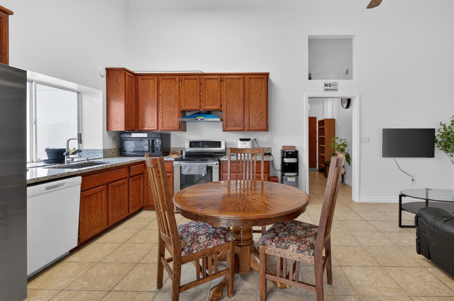 8148 Silverleaf Way Sacramento, CA 95829 - Photo 21 of 43 a large kitchen with kitchen island granite countertop a table chairs sink and cabinets