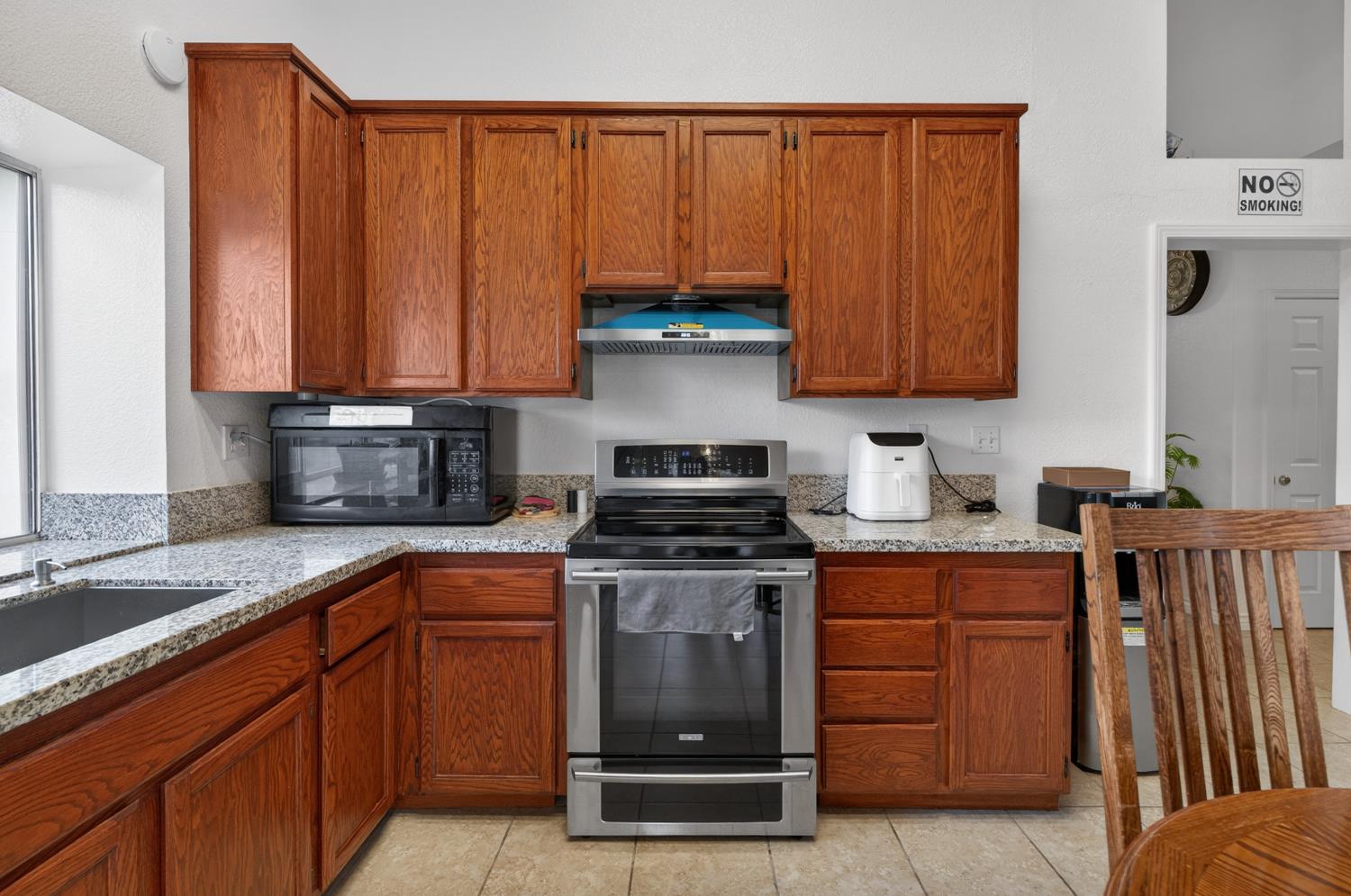 8148 Silverleaf Way Sacramento, CA 95829 - Photo 23 of 43 a kitchen with wooden cabinets and a stove top oven
