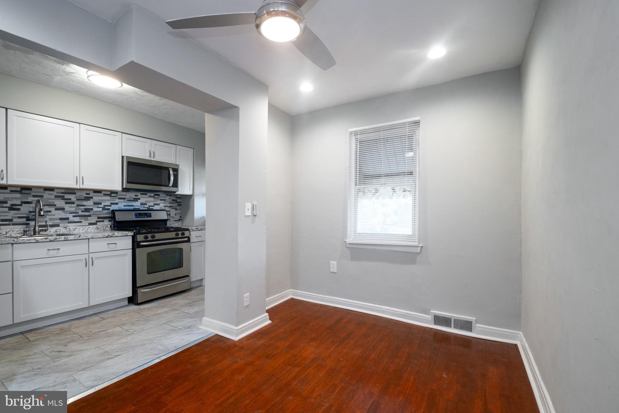 48 Hillvale Road Baltimore, MD 21229 - Photo 9 of 25 a kitchen with granite countertop a stove and a wooden floor