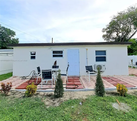 a backyard of a house with table and chairs