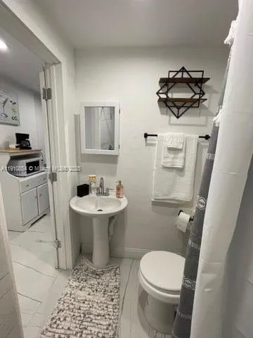 a bathroom with a toilet a sink and mirror