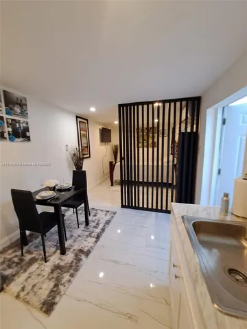 a kitchen with a table chairs sink and cabinets