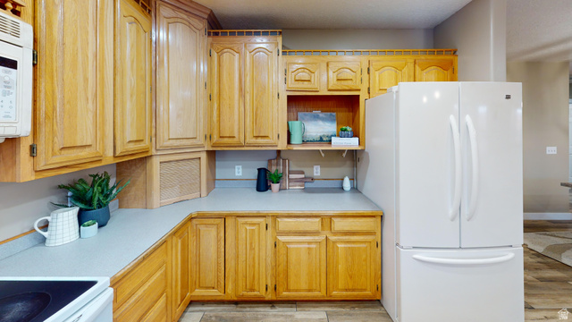 9029 North Treasureton Road Preston, ID 83263 - Photo 8 of 31 Kitchen featuring light countertops, white appliances, light wood finished floors, and open shelves