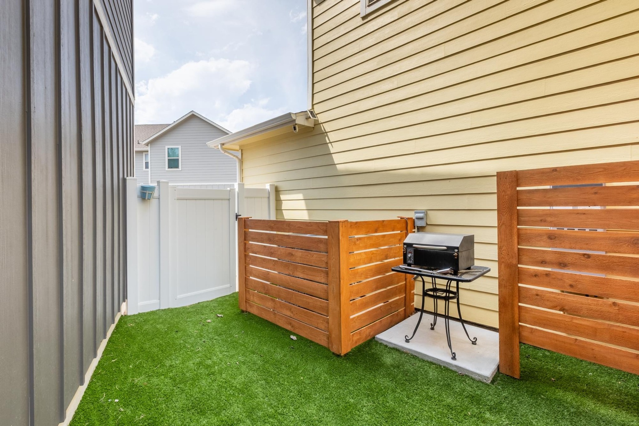 7801 Frida Bend Austin, TX 78744 - Photo 22 of 26 A compact yard offers artificial turf and a private grilling area, perfect for small outdoor gatherings.