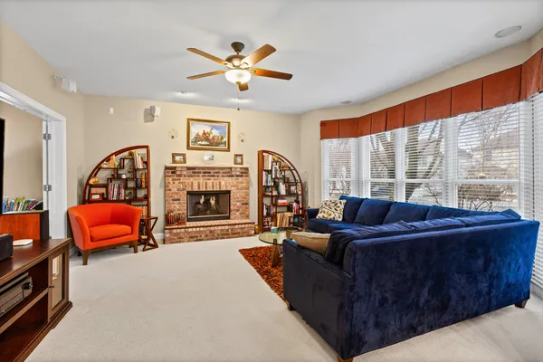 a living room with furniture a large window and a fireplace
