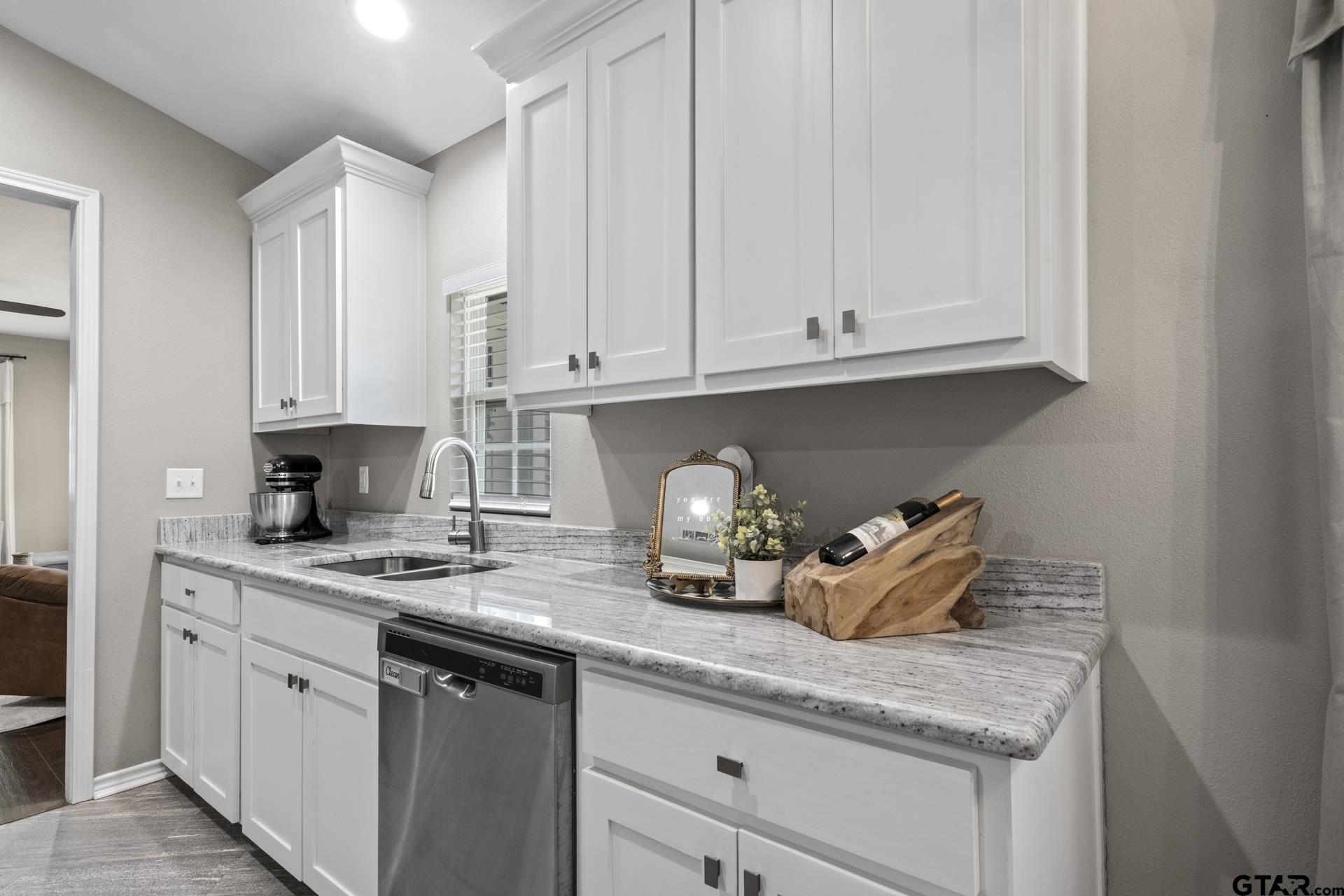 655 Daingerfield Street Pittsburg, TX 75686 - Photo 10 of 27 a kitchen with granite countertop white cabinets and white appliances