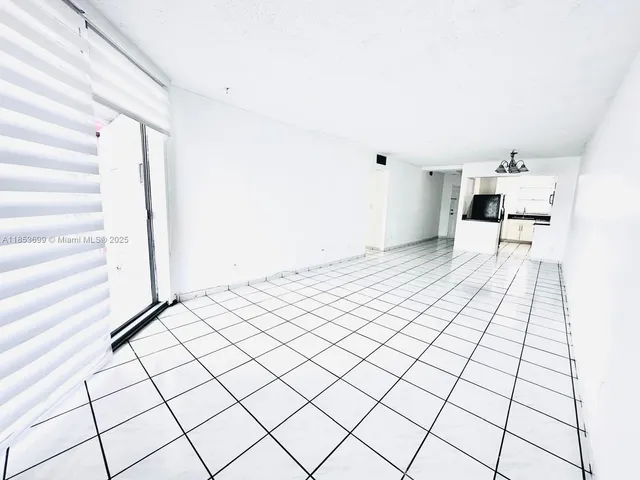 a kitchen with a sink a stove and white cabinets