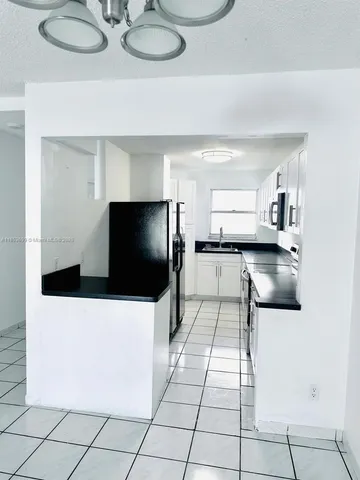 a kitchen with stainless steel appliances kitchen island granite countertop a refrigerator and a stove top oven