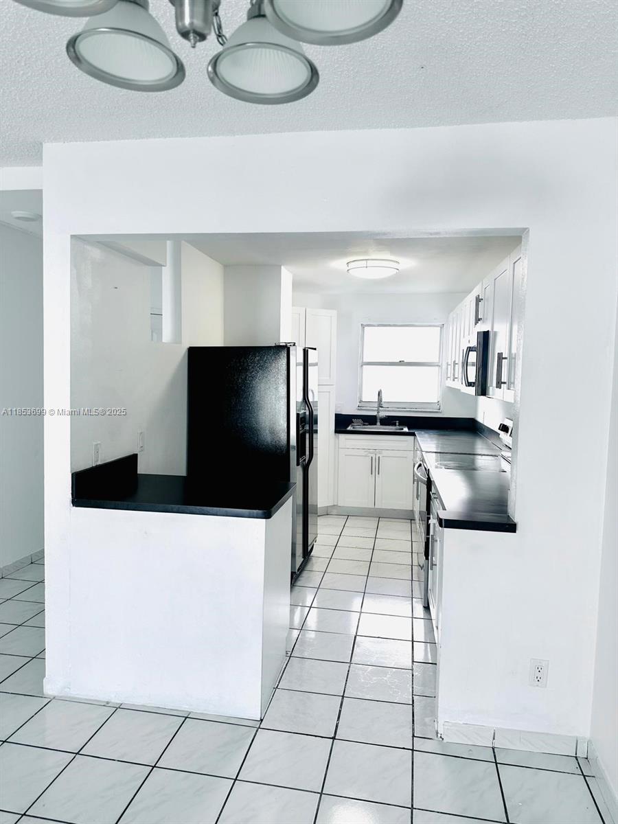 1750 West 46th Street, Unit 535 Hialeah, FL 33012 - Photo 13 of 28 a living room with stainless steel appliances kitchen island granite countertop a sink and a stove top oven