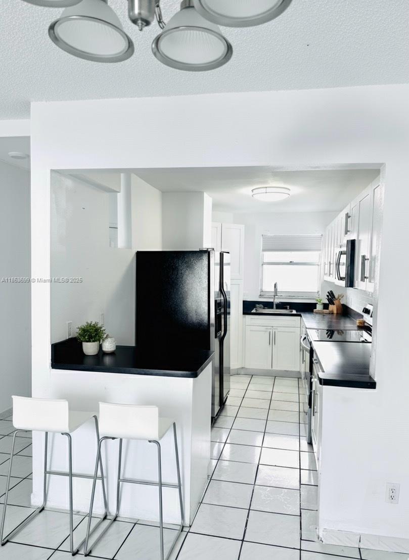 1750 West 46th Street, Unit 535 Hialeah, FL 33012 - Photo 3 of 28 a living room with furniture and a flat screen tv