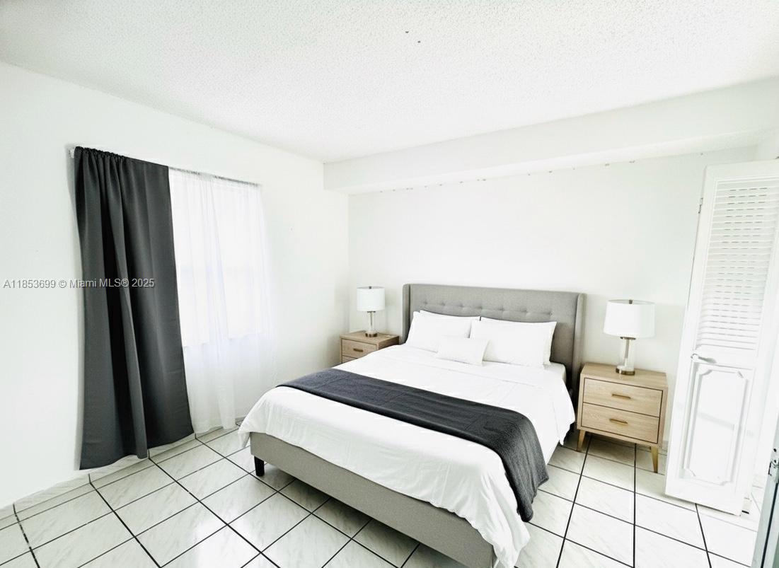 1750 West 46th Street, Unit 535 Hialeah, FL 33012 - Photo 9 of 28 a bedroom with a bed and a mirror
