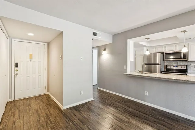a view of a kitchen with wooden floor and a sink