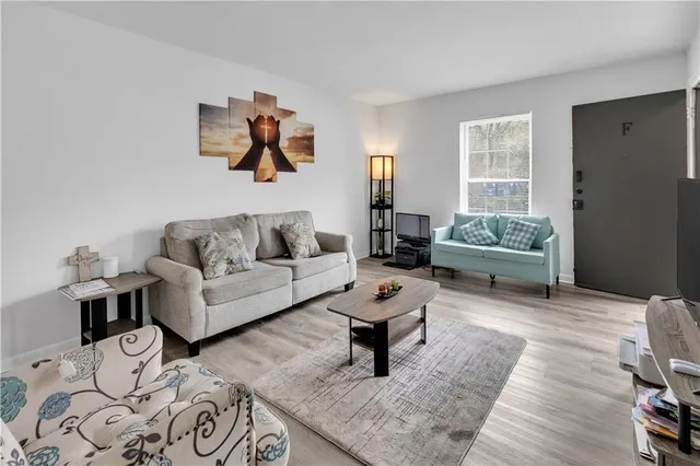 a living room with furniture and wooden floor