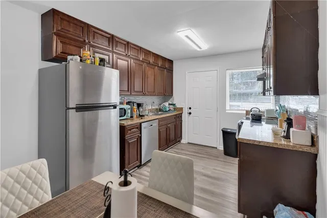 a kitchen with a refrigerator sink and wooden floor
