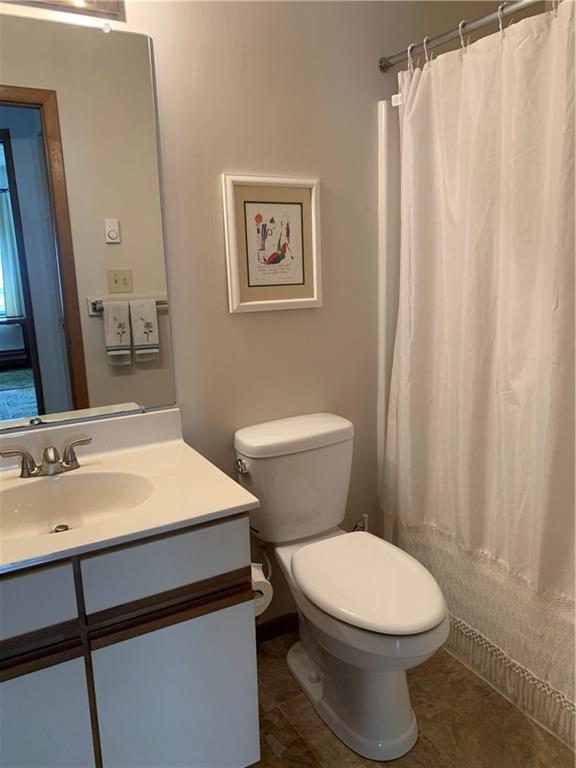 2713 Powder Ridge Road Hidden Valley, PA 15502 - Photo 16 of 30 a bathroom with a sink a toilet a mirror and shower curtain
