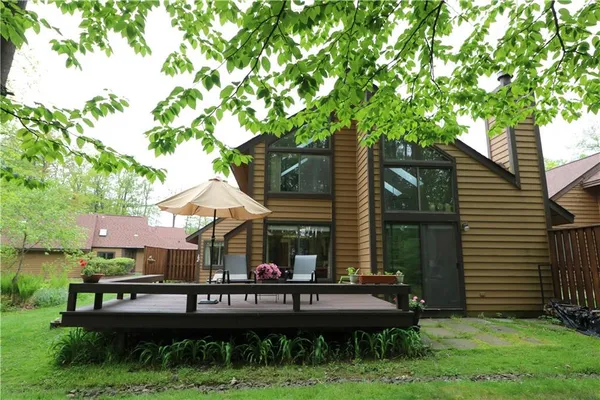 a backyard of a house with yard table and chairs