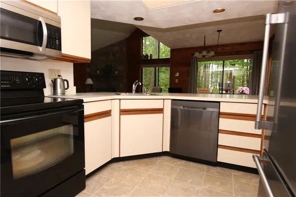 a kitchen with stainless steel appliances granite countertop a stove a sink and a microwave