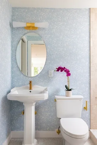 a bathroom with a toilet sink and mirror