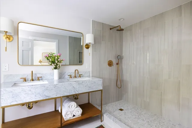 a bathroom with a granite countertop shower sink and mirror