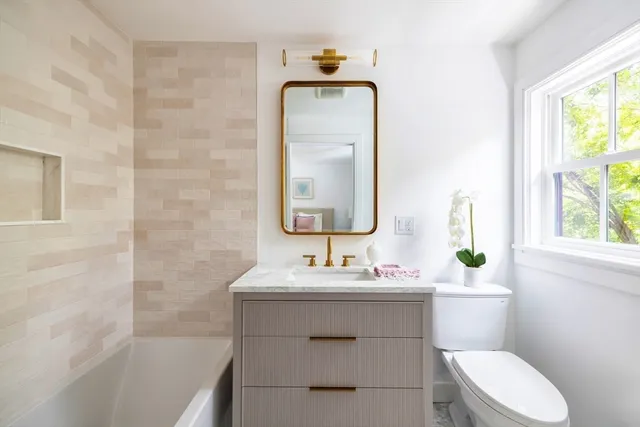 a bathroom with a sink vanity mirror and toilet
