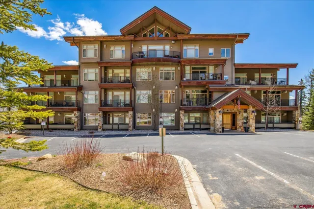 a front view of a residential apartment building with a yard