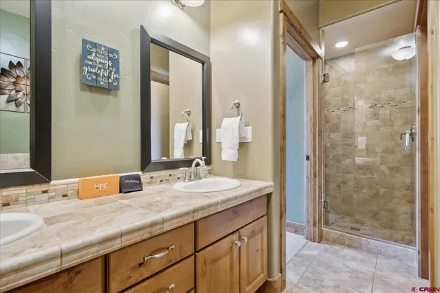 a bathroom with a granite countertop sink mirror and shower
