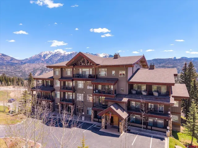 a front view of a house with yard and balcony