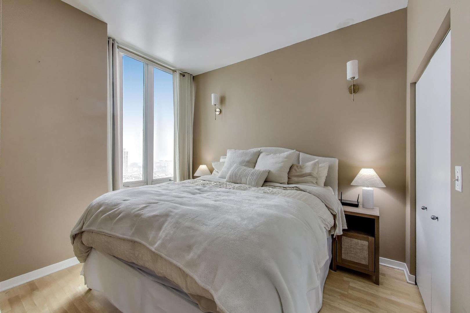 1600 South Indiana Avenue, Unit 1602 Chicago, IL 60616 - Photo 13 of 26 a bed sitting in a bedroom next to a window