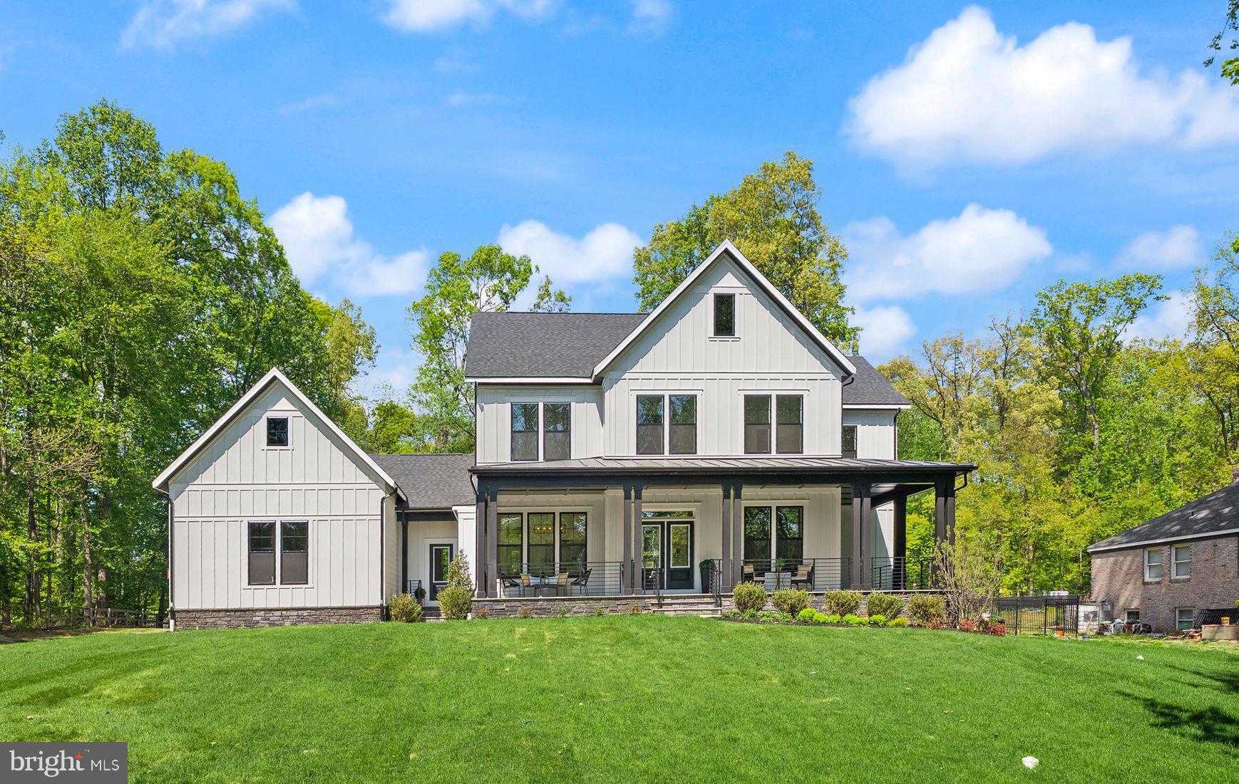 a front view of a house with a yard and trees