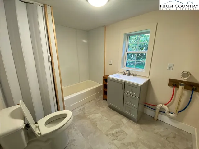 a bathroom with a sink a toilet a mirror and shower