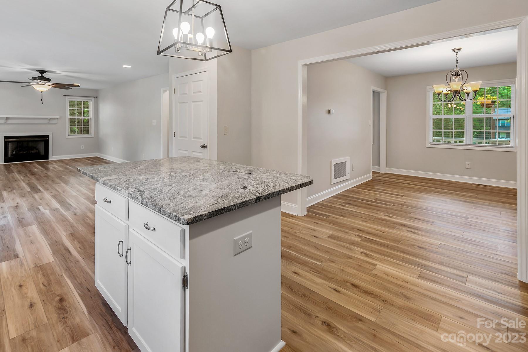 211 Todd Circle Wingate, NC 28174 - Photo 11 of 45 a kitchen with granite countertop a sink dishwasher and white cabinets with wooden floor