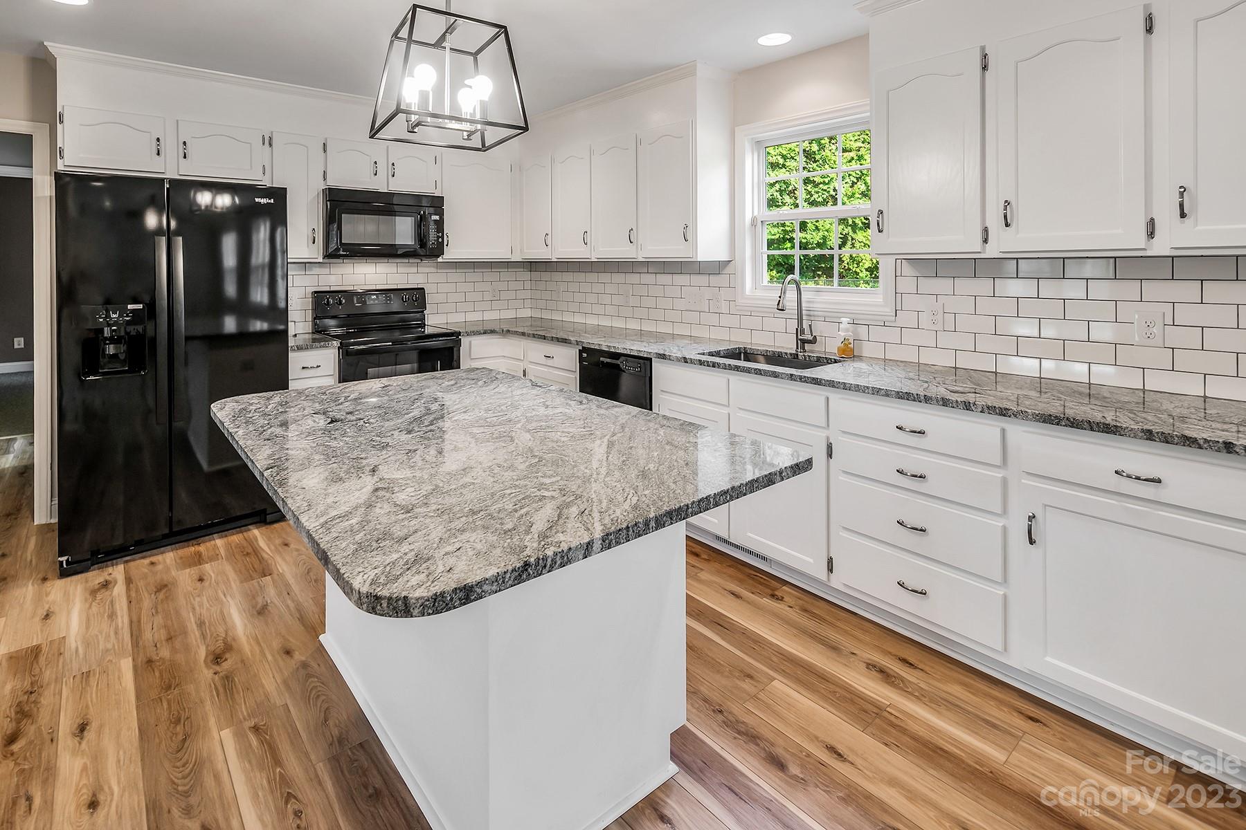 211 Todd Circle Wingate, NC 28174 - Photo 12 of 45 a kitchen with stainless steel appliances kitchen island granite countertop a refrigerator a sink dishwasher a stove and white cabinets