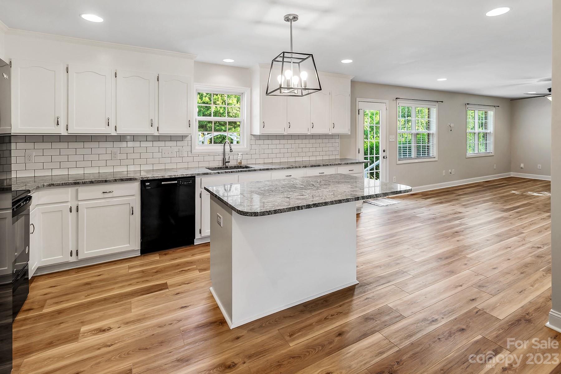 211 Todd Circle Wingate, NC 28174 - Photo 14 of 45 a kitchen with granite countertop wooden floor window and cabinets