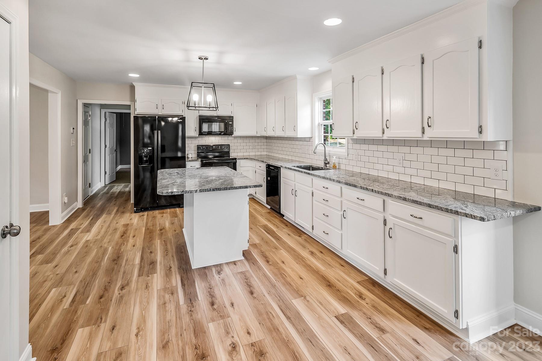 211 Todd Circle Wingate, NC 28174 - Photo 15 of 45 a large kitchen with stainless steel appliances granite countertop a lot of counter space and wooden floors