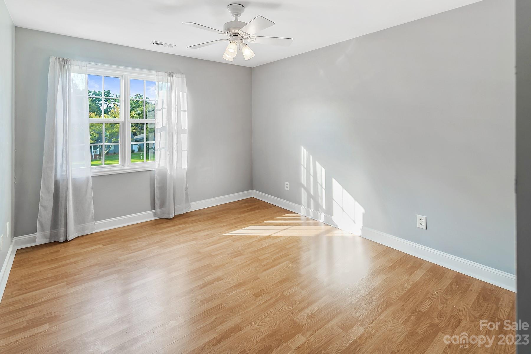 211 Todd Circle Wingate, NC 28174 - Photo 25 of 45 an empty room with wooden floor fan and windows