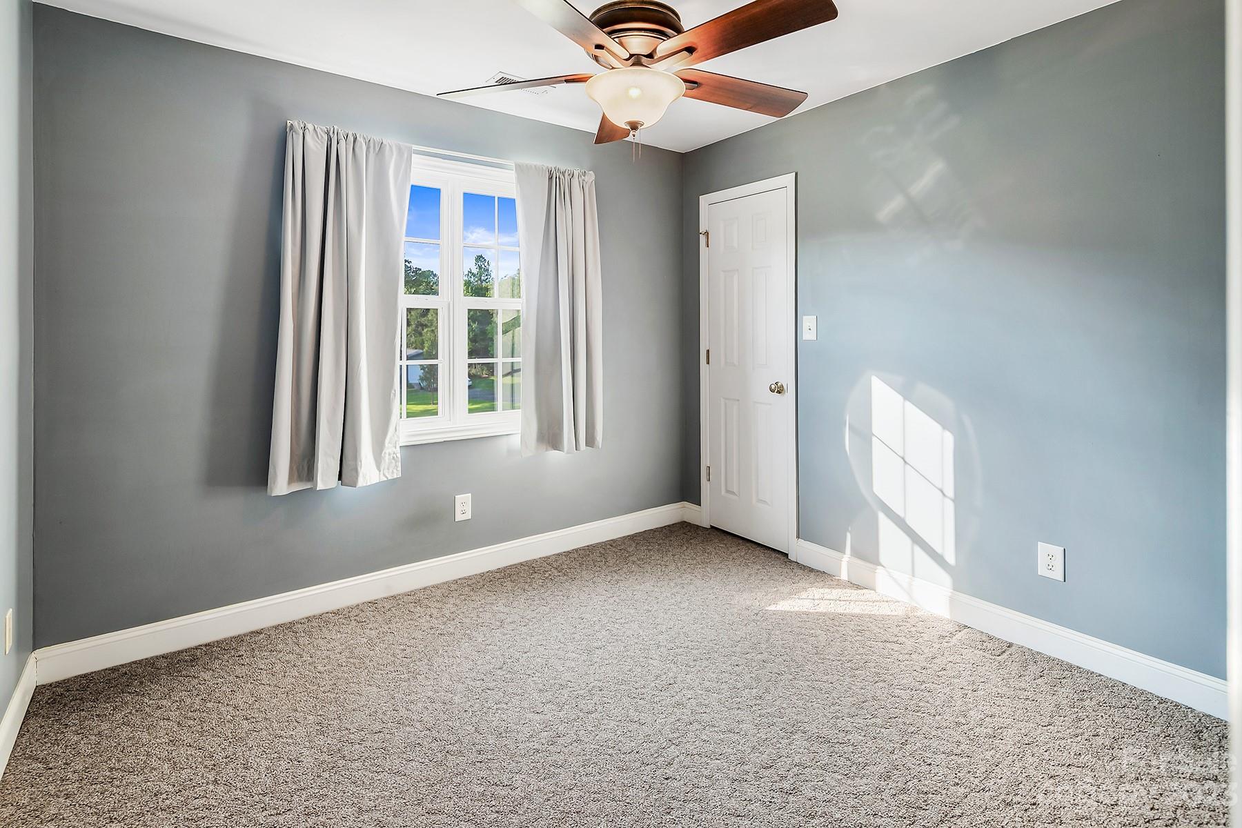 211 Todd Circle Wingate, NC 28174 - Photo 28 of 45 an empty room with chandelier fan and windows