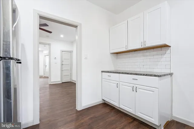 an empty room with wooden floor and cabinet