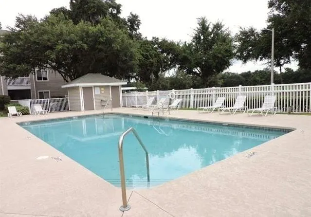 a view of a house with pool and chairs