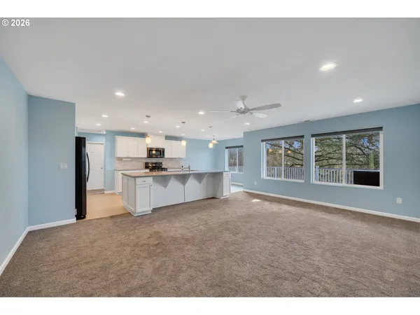 a view of kitchen with refrigerator and windows