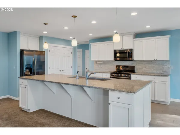 a kitchen with appliances a sink and cabinets