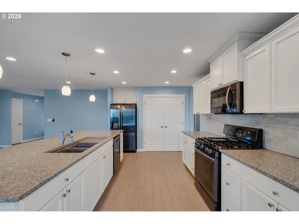 a kitchen with granite countertop a sink stove and cabinets