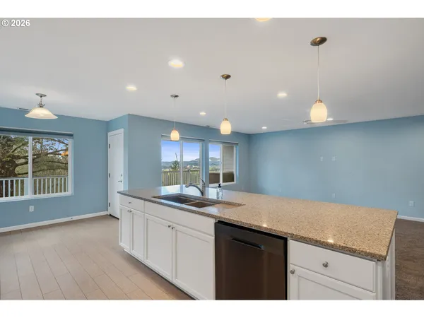 a kitchen with a sink a window and wooden floor
