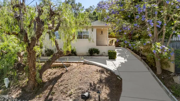 a view of a house with a yard and sitting area