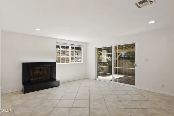 an empty room with a fireplace and windows