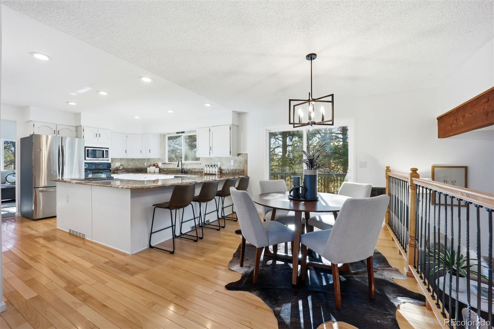 9212 East Tanglewood Road Franktown, CO 80116 - Photo 14 of 50 a view of a dining room with furniture window and wooden floor