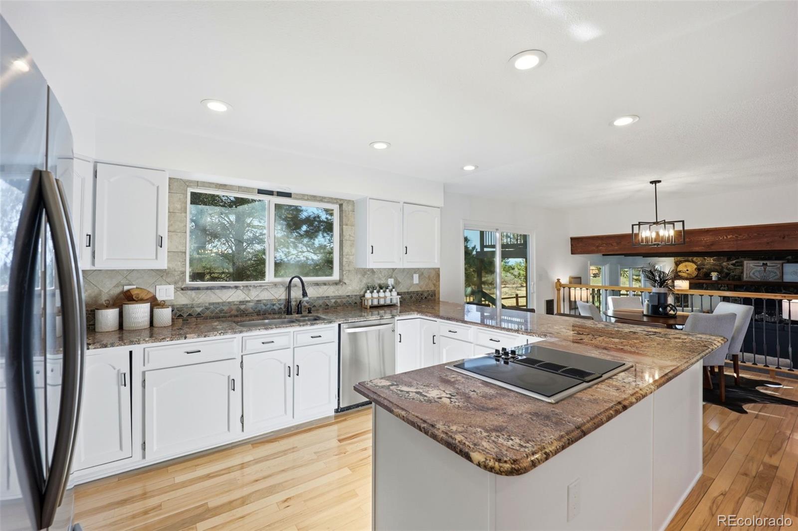9212 East Tanglewood Road Franktown, CO 80116 - Photo 17 of 50 a kitchen with stainless steel appliances granite countertop a sink stove and refrigerator