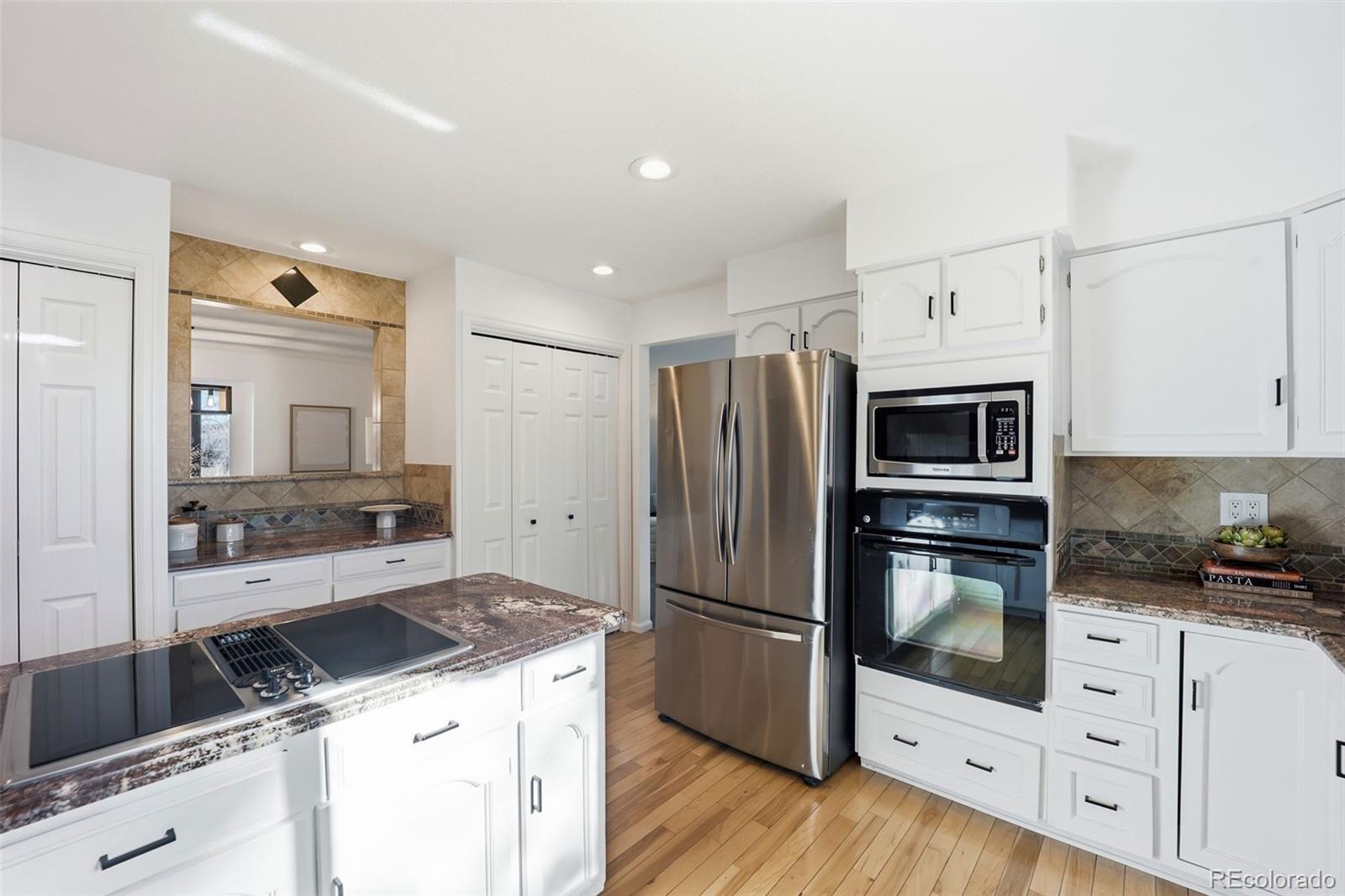 9212 East Tanglewood Road Franktown, CO 80116 - Photo 19 of 50 a kitchen with granite countertop a sink stove and refrigerator