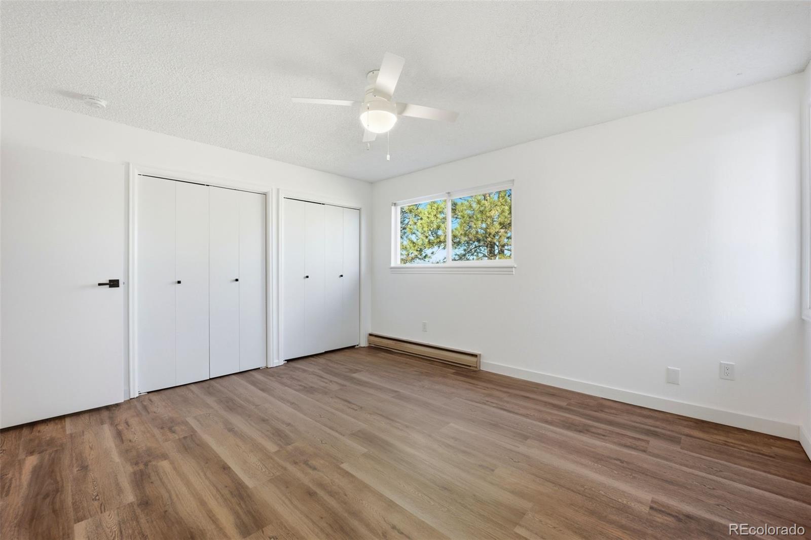 9212 East Tanglewood Road Franktown, CO 80116 - Photo 31 of 50 a view of an empty room with wooden floor and a window